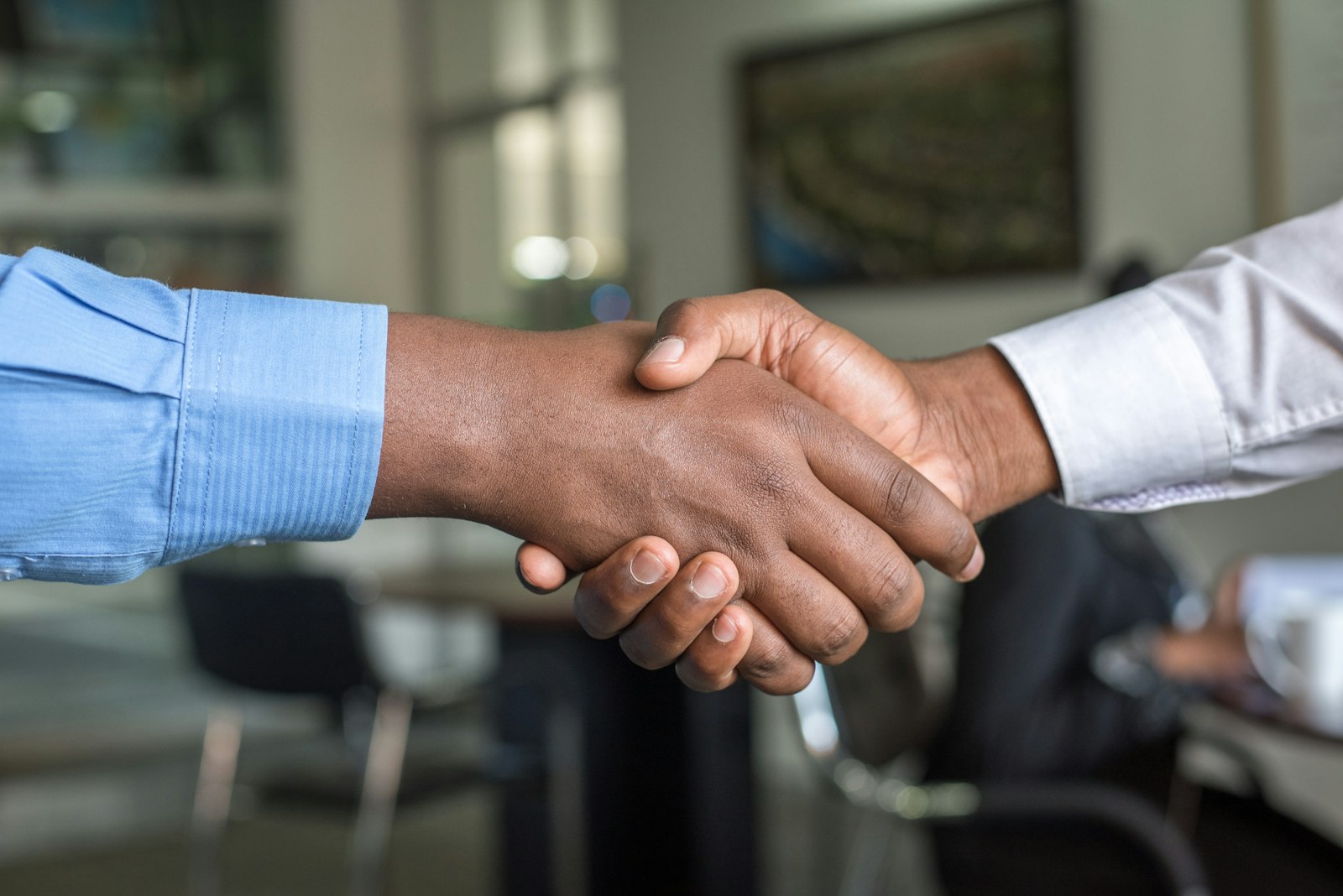 Two executives shaking hands across a table